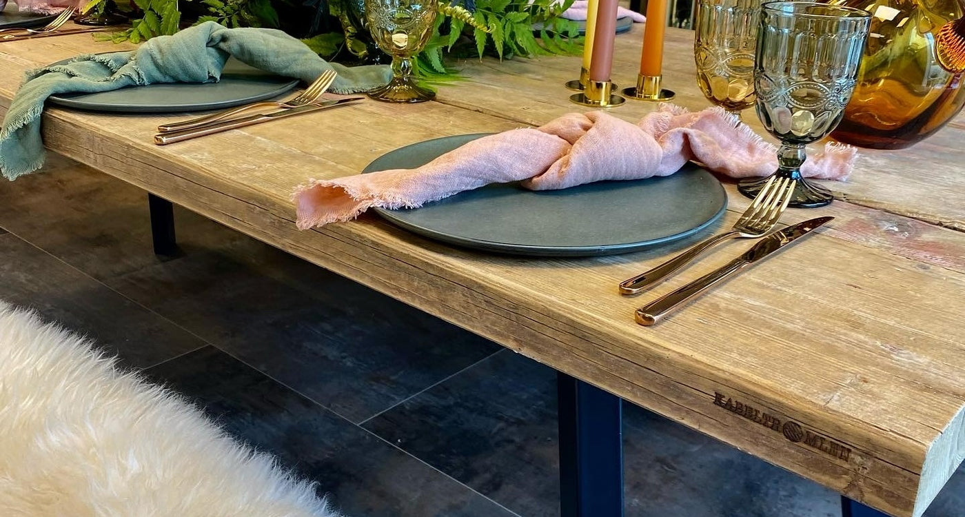 Plankebord af genbrugsplanker dækket op med service og glas