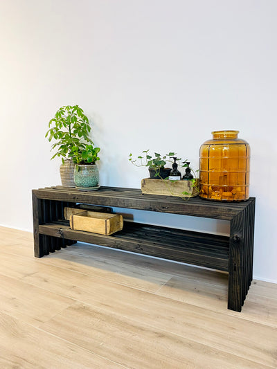 Flot sort skoreol af traller stylet med glasvase, murstensforme og planter